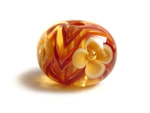 Ivory flower, dark red ribbon encased in pale amber